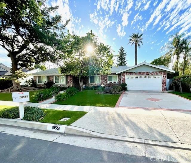 single story home with an attached garage, brick siding, concrete driveway, and a front yard