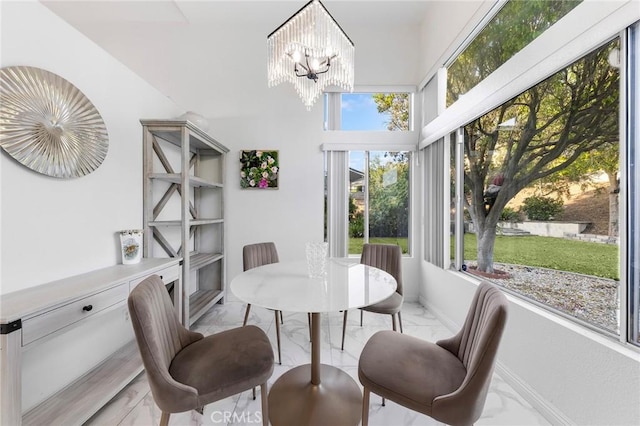 dining space with marble finish floor, baseboards, and a chandelier