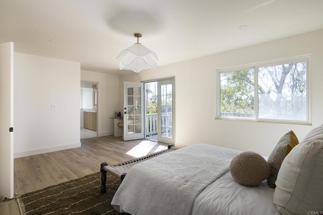 bedroom with access to outside, baseboards, and wood finished floors