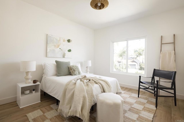 bedroom featuring baseboards and wood finished floors