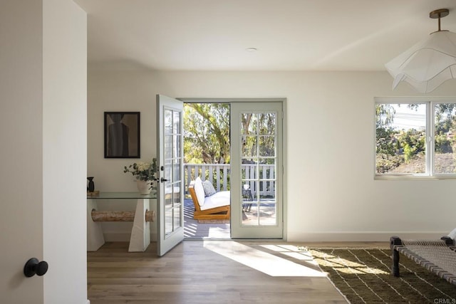 doorway featuring french doors, baseboards, and wood finished floors