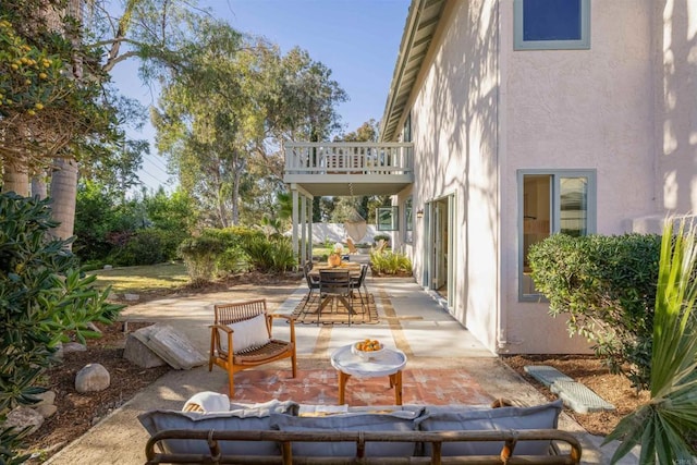 view of patio with outdoor dining space and a balcony