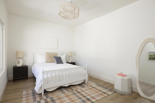 bedroom with baseboards and wood finished floors