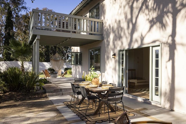 view of patio with outdoor dining area and a balcony