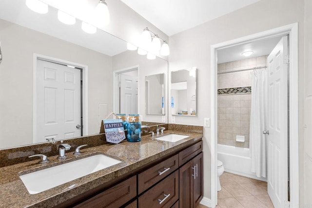 bathroom featuring double vanity, a sink, toilet, and tile patterned floors