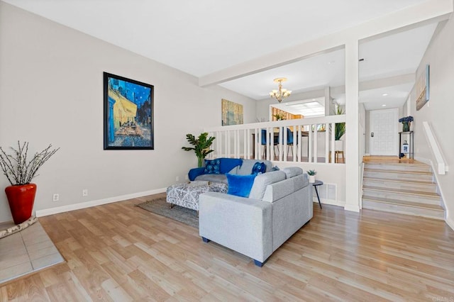 living room with a notable chandelier, visible vents, baseboards, stairs, and light wood-type flooring