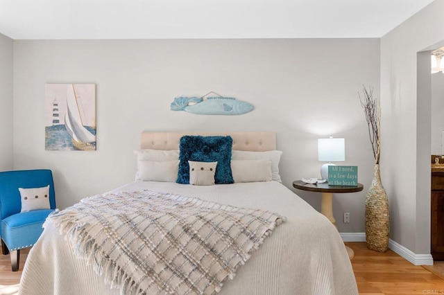 bedroom with baseboards and wood finished floors