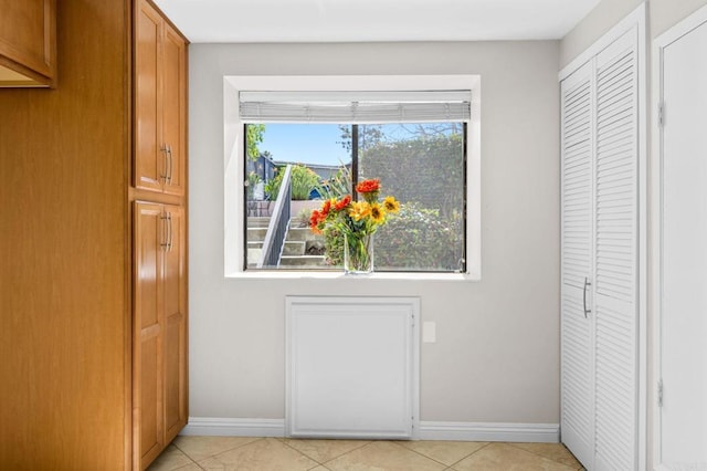 doorway to outside with light tile patterned floors and baseboards