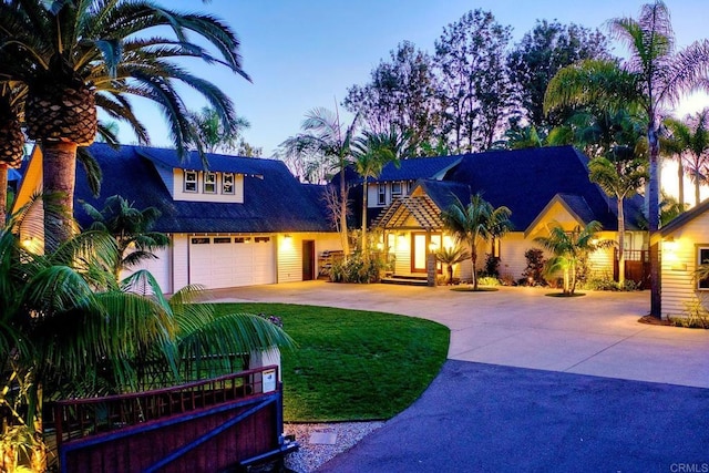 view of front of house with a garage, a yard, and driveway