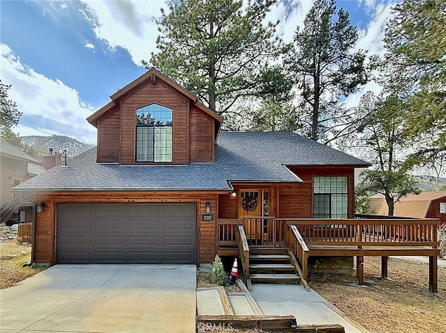 view of front of house featuring an attached garage, a shingled roof, and concrete driveway