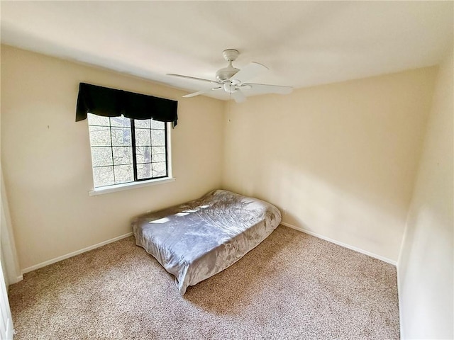 unfurnished bedroom with carpet, a ceiling fan, and baseboards