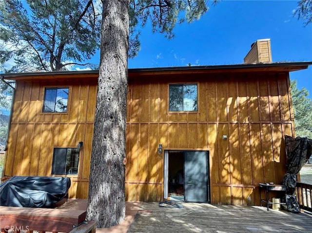 rear view of property featuring a chimney