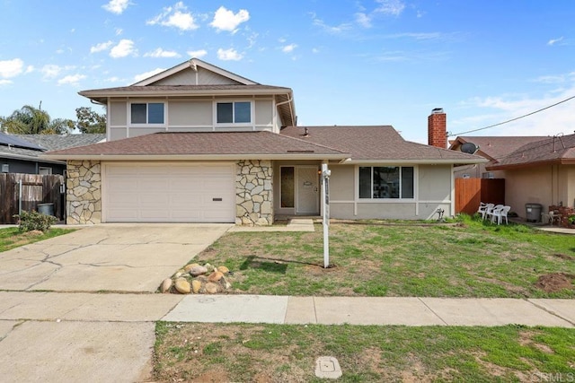 view of front facade featuring a garage, stone siding, fence, and a front yard