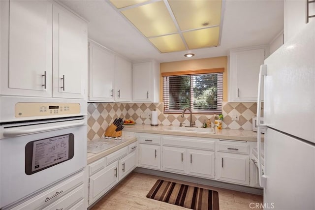 379 Avenida Castilla Unit Q, Laguna Woods, CA 92675 - kitchen with light wood-type flooring, white appliances, light countertops, white cabinetry, and a sink