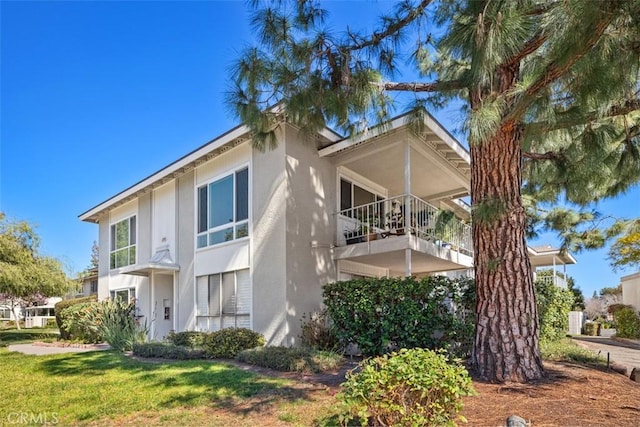 view of side of home with a yard and stucco siding