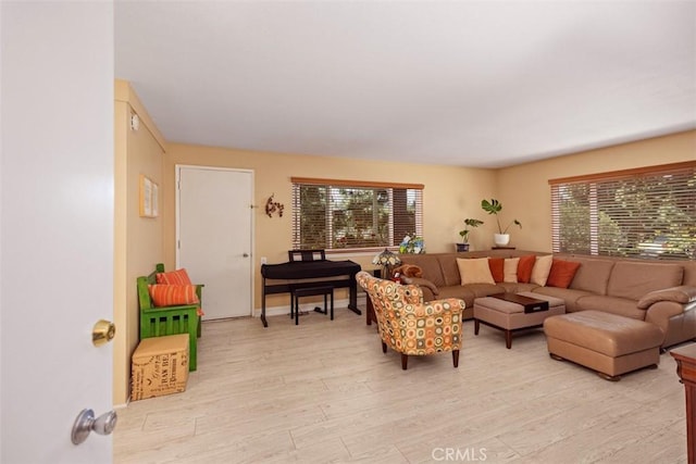 379 Avenida Castilla Unit Q, Laguna Woods, CA 92675 - living room featuring baseboards, light wood-style floors, and a healthy amount of sunlight