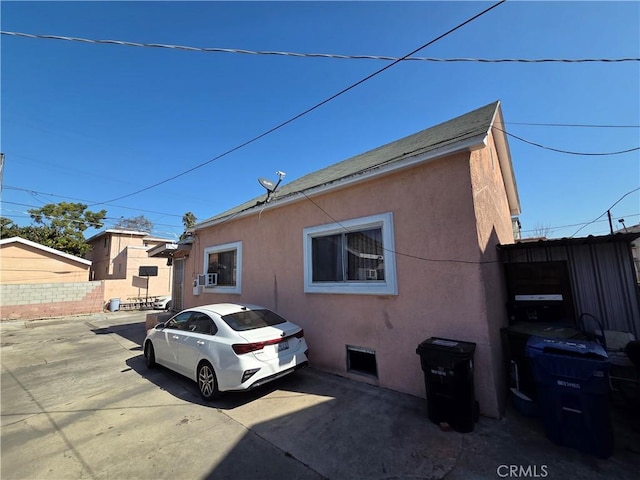 view of property exterior with fence and stucco siding