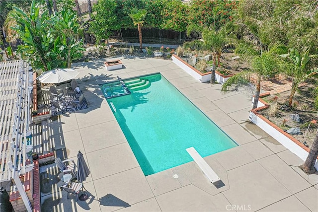 view of swimming pool featuring a diving board, a fenced in pool, fence, and a patio