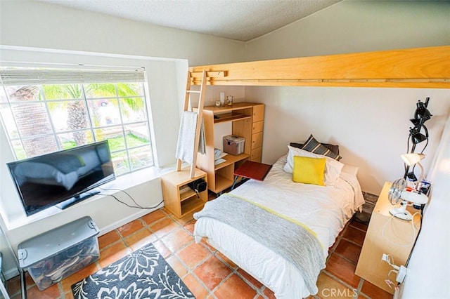 bedroom with vaulted ceiling and a textured ceiling