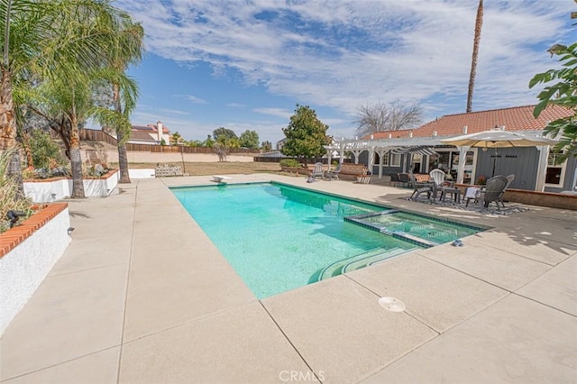 view of swimming pool with a patio area, a pool with connected hot tub, and a pergola