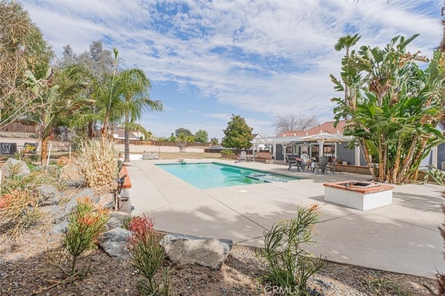 pool featuring a patio area, an outdoor fire pit, fence, and a pergola