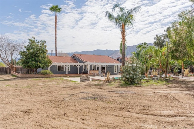 rear view of house with a patio area, fence, and a mountain view