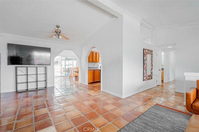 living area featuring light tile patterned floors, baseboards, arched walkways, ceiling fan, and crown molding