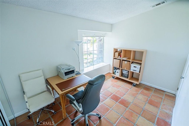 office space with baseboards, visible vents, and a textured ceiling