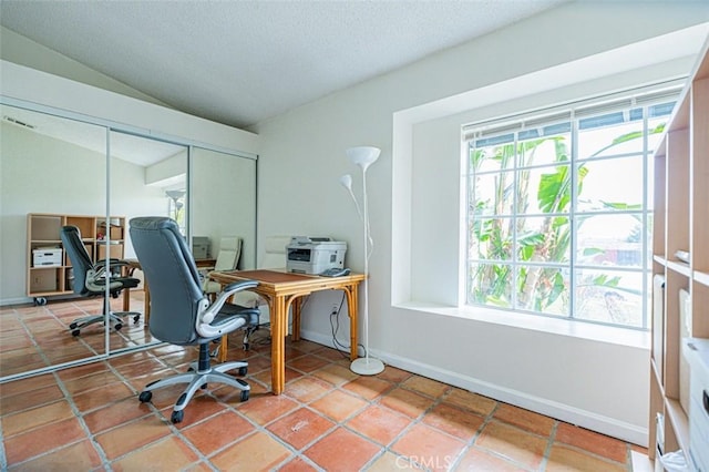 tiled home office with plenty of natural light, baseboards, vaulted ceiling, and a textured ceiling