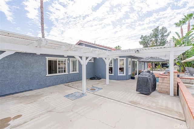 back of house with stucco siding, a patio, and a pergola