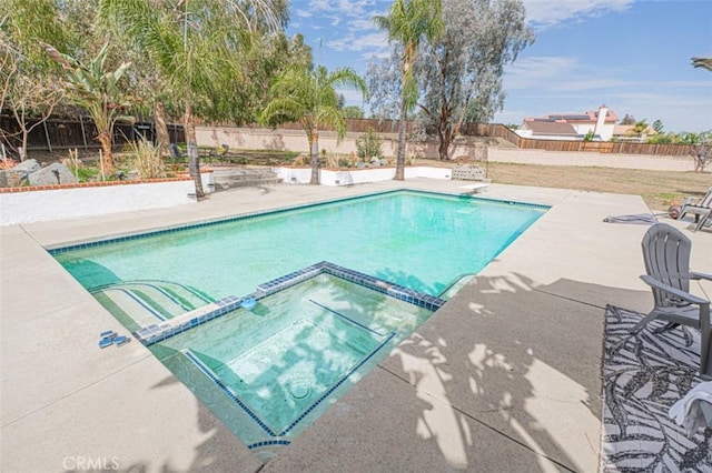 view of pool featuring a diving board, a patio, a fenced backyard, and a pool with connected hot tub