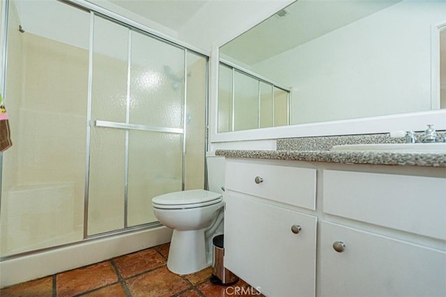 bathroom featuring a shower stall, toilet, and vanity