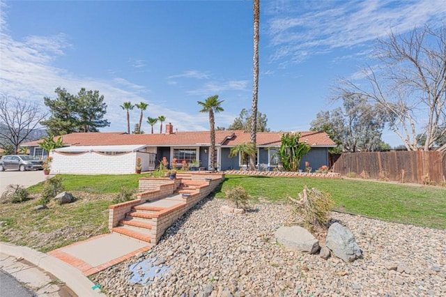 ranch-style house with a front yard and fence