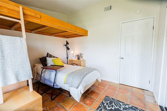 bedroom with tile patterned flooring and visible vents