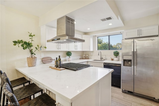 kitchen with visible vents, white cabinets, a sink, black appliances, and extractor fan