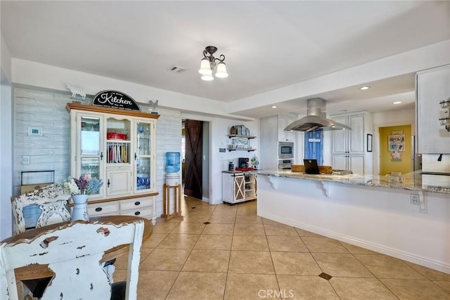2056 Wonderview Dr, Vista, CA 92084 - kitchen with island range hood, light tile patterned floors, stainless steel appliances, light stone countertops, and white cabinets