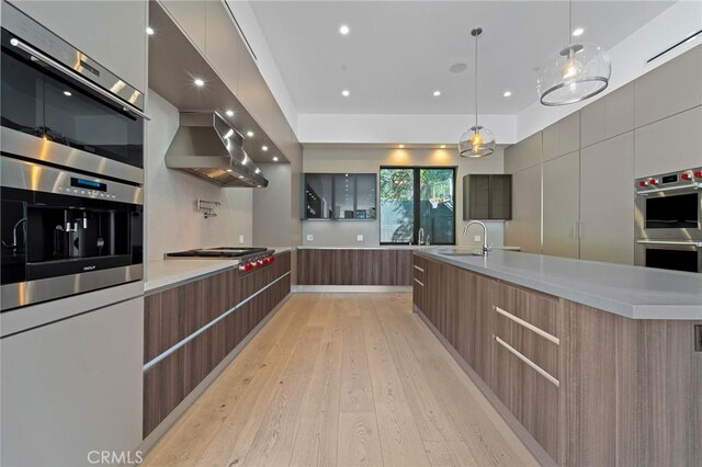 4653 Vanalden Ave, Tarzana, CA 91356 - kitchen featuring modern cabinets, a sink, light wood-style floors, stainless steel appliances, and light countertops