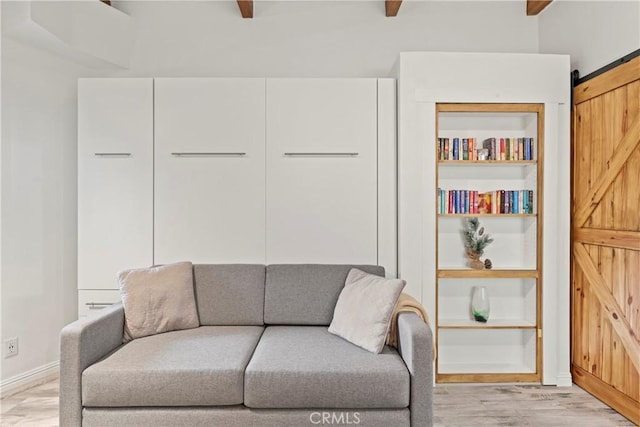 750 Zurich Dr, Lake Arrowhead, CA 92352 - living area featuring beamed ceiling, a barn door, baseboards, and light wood-style floors