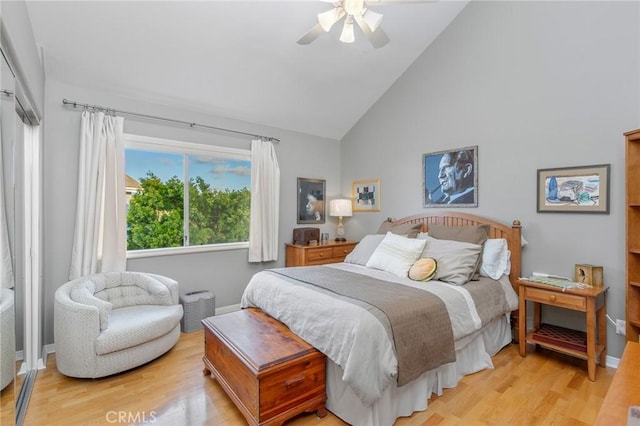 bedroom with ceiling fan, high vaulted ceiling, baseboards, and light wood-style floors