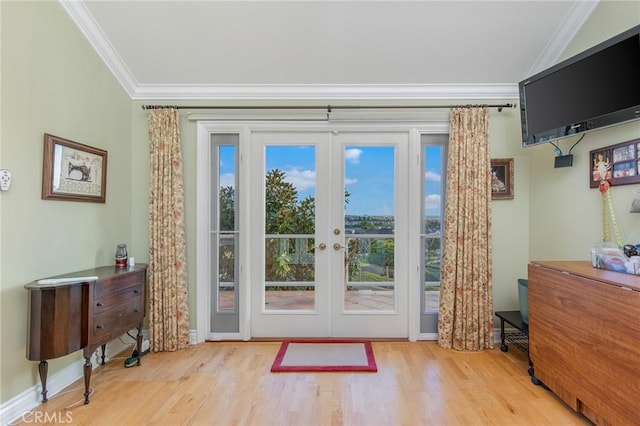 doorway to outside with baseboards, ornamental molding, wood finished floors, and french doors