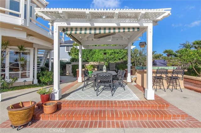 view of patio featuring outdoor dining area, outdoor dry bar, and a pergola