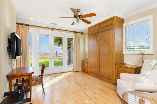 sitting room with light wood-type flooring, a ceiling fan, crown molding, and french doors