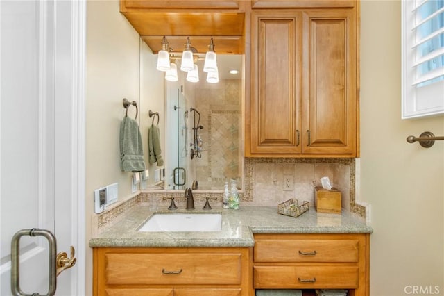 bathroom featuring tasteful backsplash, a tile shower, and vanity