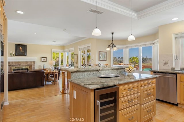 kitchen with visible vents, light wood-style flooring, wine cooler, a brick fireplace, and stainless steel dishwasher