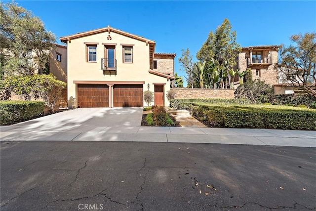 mediterranean / spanish home with stucco siding, concrete driveway, and an attached garage