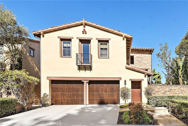 mediterranean / spanish-style house with stucco siding, concrete driveway, an attached garage, and a tiled roof