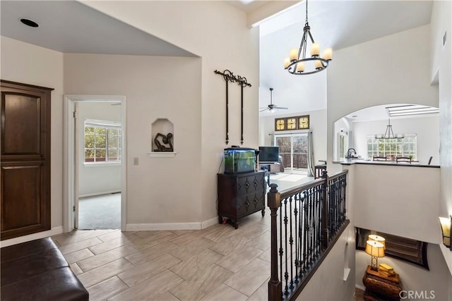 892 Breithorn Dr, Lake Arrowhead, CA 92352 - corridor with arched walkways, baseboards, a chandelier, and an upstairs landing