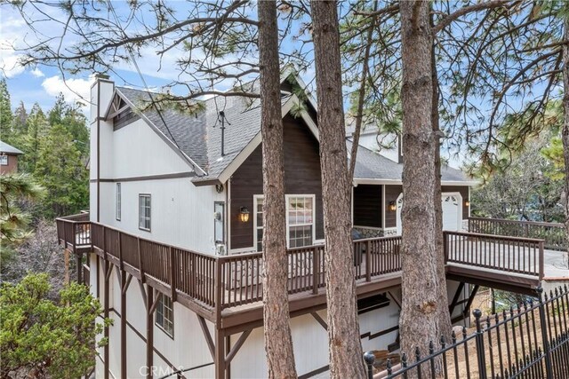 892 Breithorn Dr, Lake Arrowhead, CA 92352 - back of house with a wooden deck, fence, roof with shingles, a chimney, and an attached garage