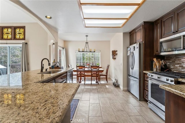 892 Breithorn Dr, Lake Arrowhead, CA 92352 - kitchen featuring a sink, light stone counters, stainless steel appliances, and a healthy amount of sunlight