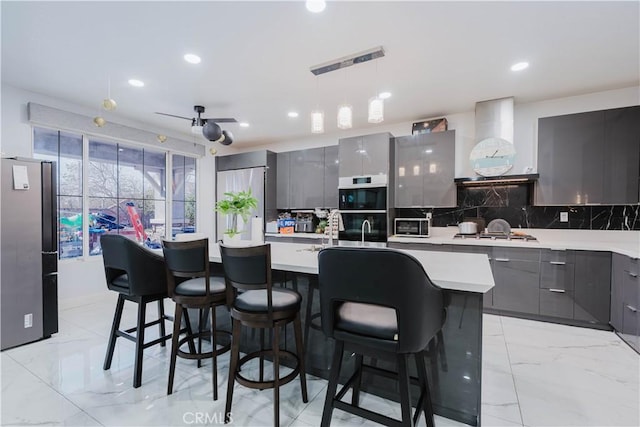 kitchen with wall chimney exhaust hood, modern cabinets, marble finish floor, light countertops, and gray cabinetry